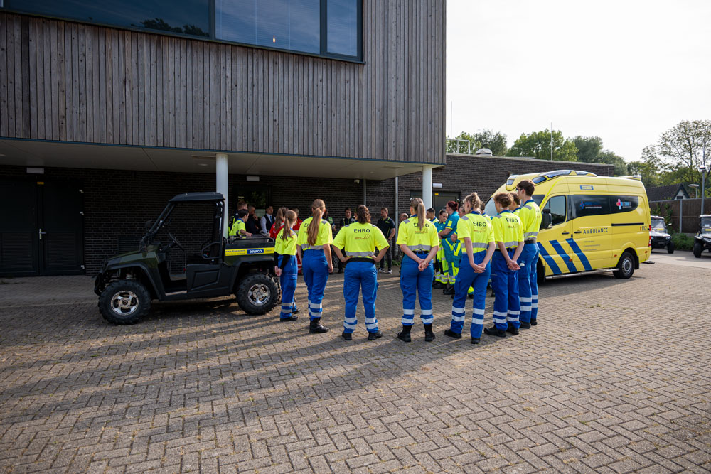 EHBO-medewerkers verzamelen zich bij een ambulance en terreinvoertuig voorafgaand aan hun inzet bij een evenement.
