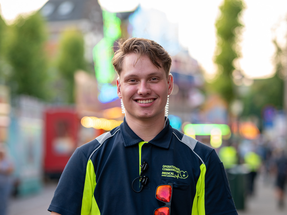 Portret van een medewerker van Medical Event Assistance tijdens een druk evenement in de stad.