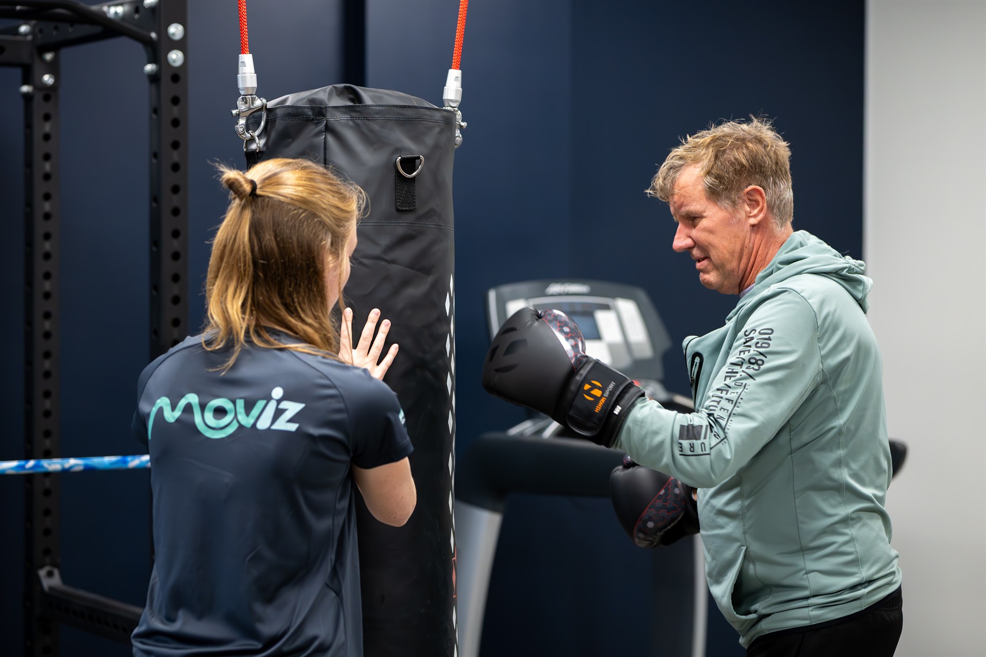Fysiotherapeut van Moviz begeleidt een cliënt tijdens een bokstraining, onderdeel van de bedrijfsreportage voor de rebranding naar Moviz