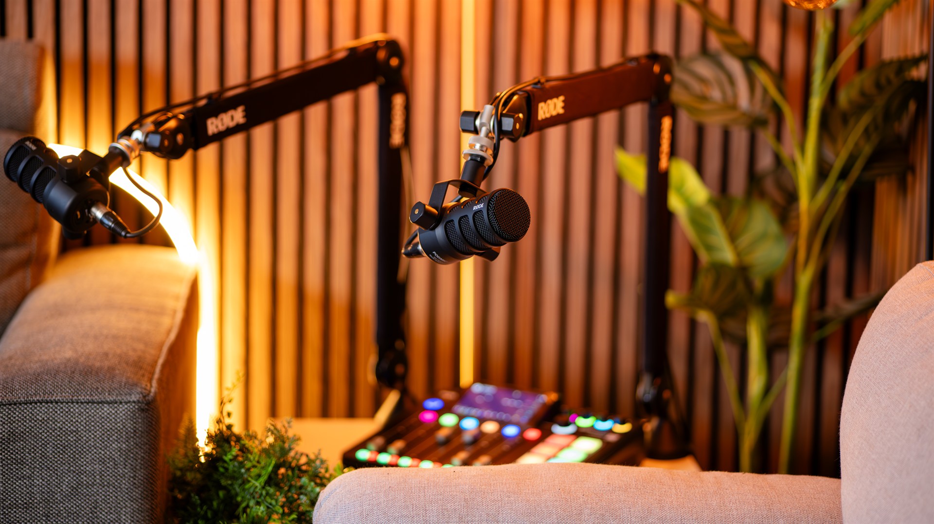 Professionele videopodcaststudio van Mendus Productions met RØDE-microfoons, houten lattenwand en warme belichting